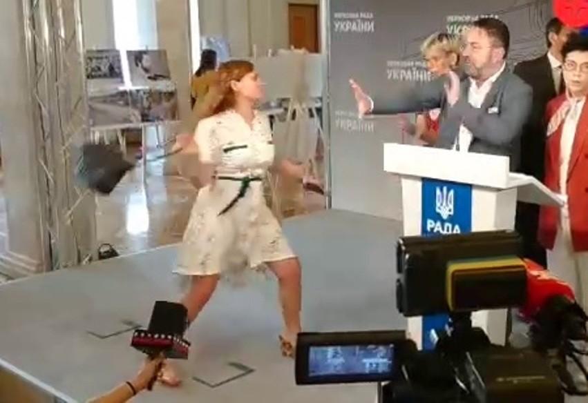 Відео дня. Жінка вдарила сумочкою “Слугу народу” Потураєва в кулуарах Ради