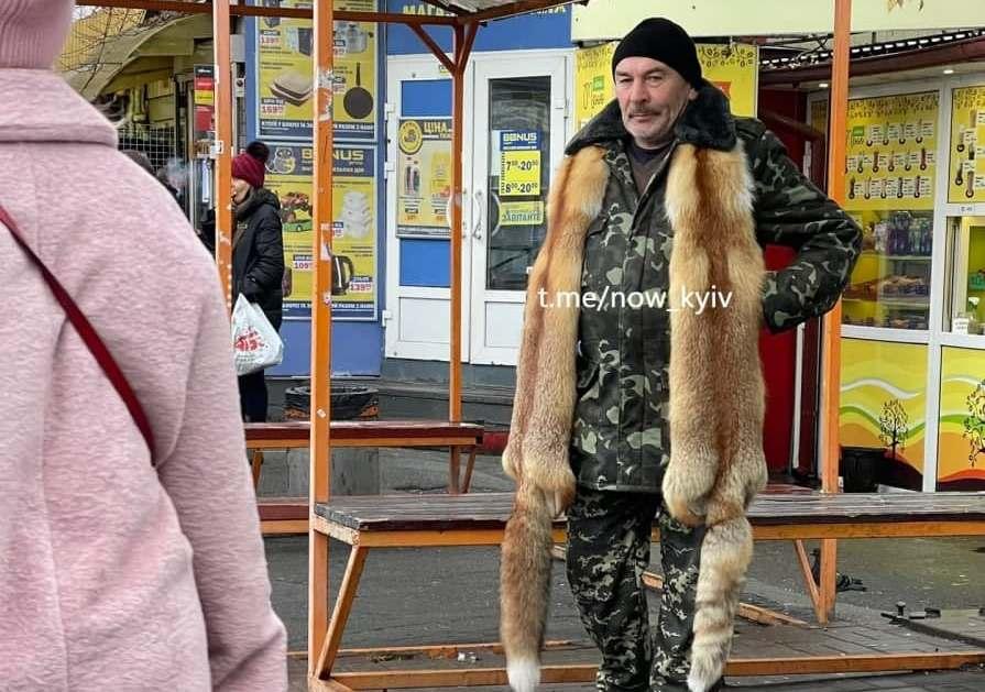 Фото дня. Чоловік на зупинці з хутром двох лисиць на шиї