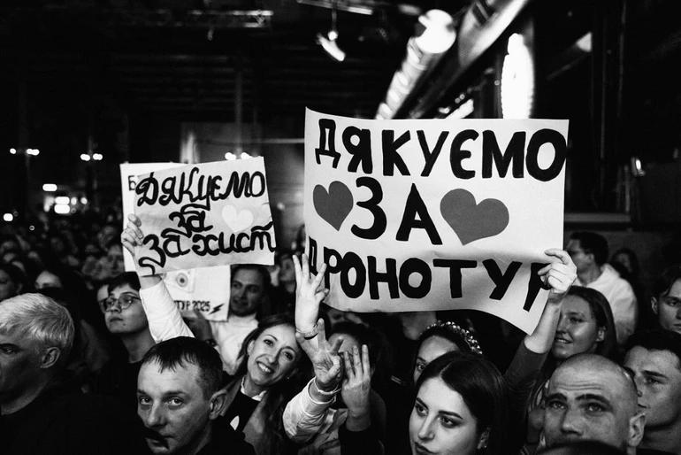 Люди стоять з плакатами вдячності на концерті гурту "Бумбокс" у Штутгарті